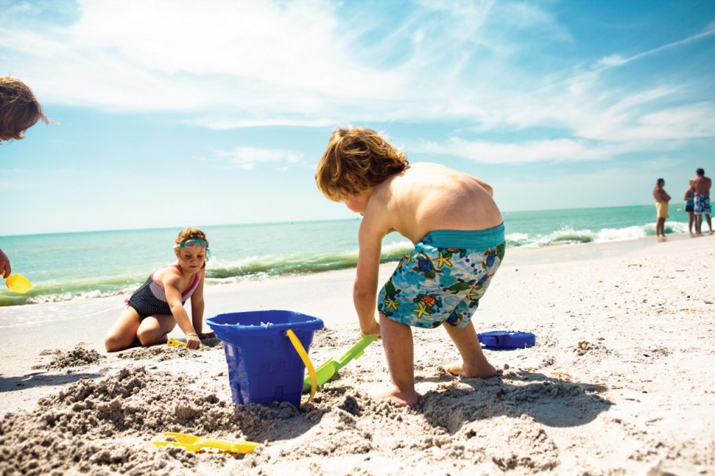 Children play in the sand on the beach with colorful plastic beachtoys.