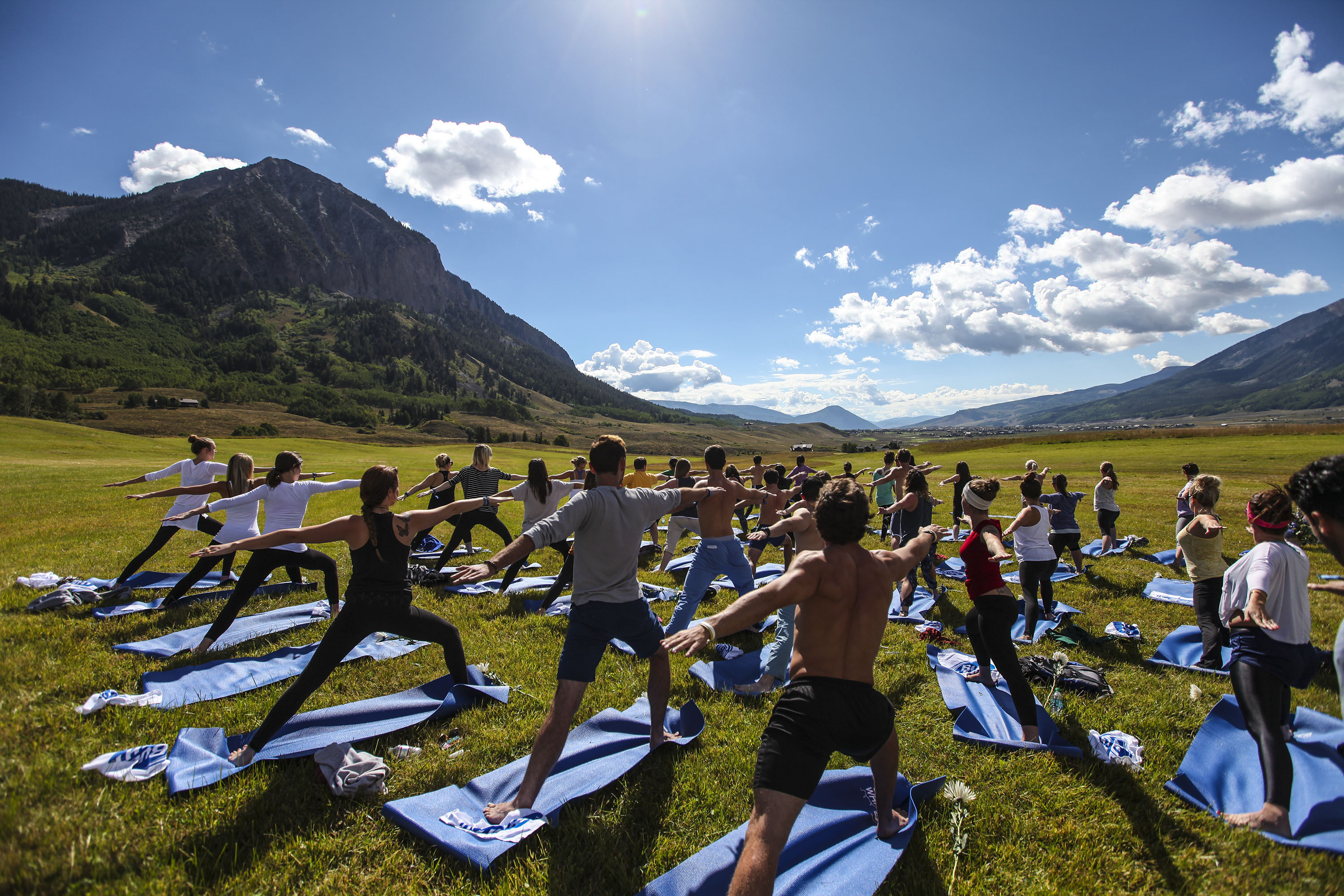 Yoga learners strike a pose in a field near Aspen, Colorado. Image by Jason Bahr / Getty