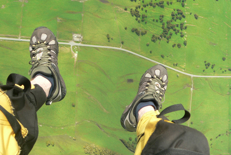 Feet and ground below during tandem skydive over Franz Josef, New Zealand. Image by Paul Kelly / Flickr / Getty Images.