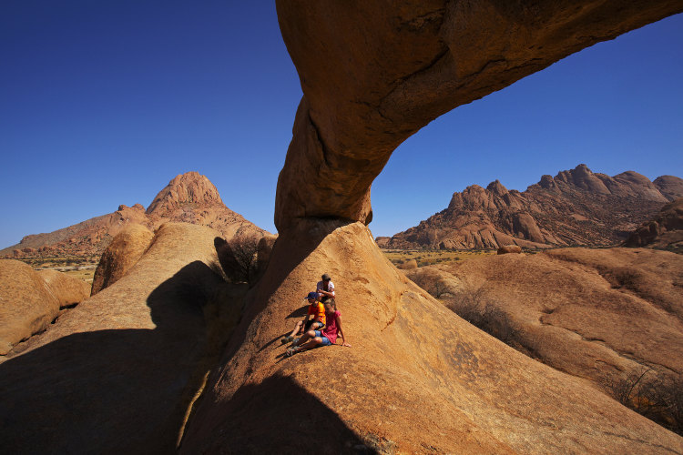 A natural rock arch at Spitzkoppe (summit on left), Namibia. Image by Danita Delimont / Getty Images