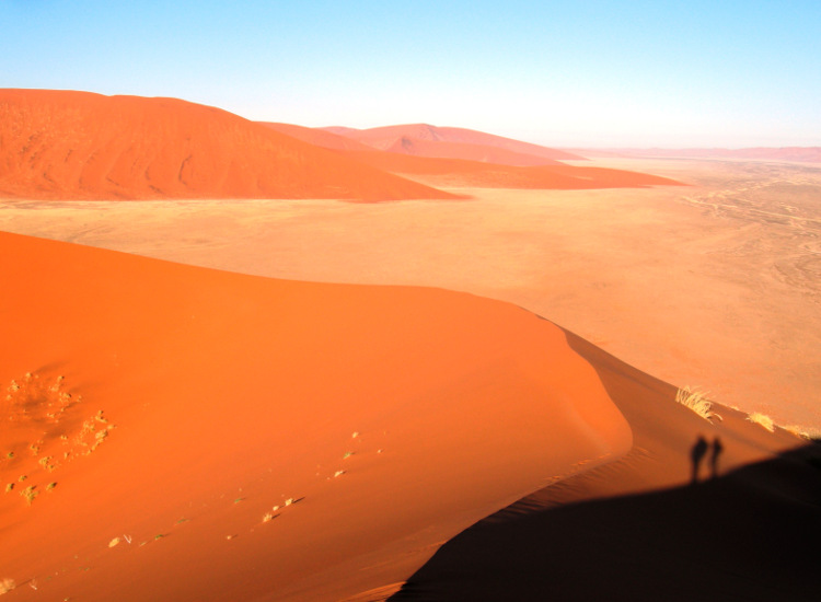 Silhouettes of climbers at Sossusvlei, Namib-Naukluft National Park, Namibia. Image by Monica Guy