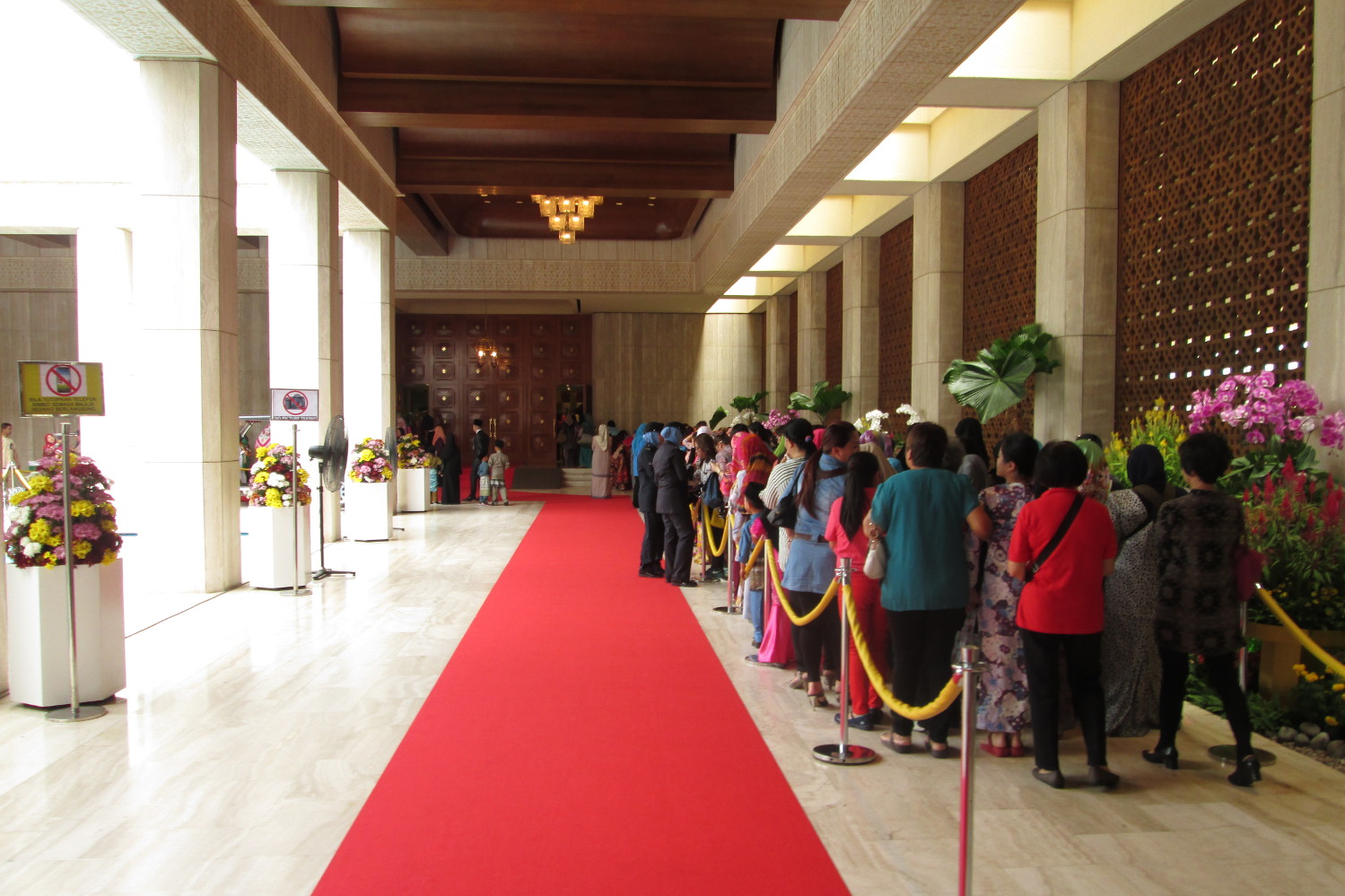 Women queue in front of the room where Brunei's Queen Consort greets female guests © Isabel Albiston / Lonely Planet