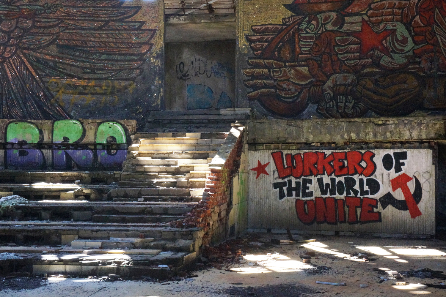 Modern graffiti inside the Buzludzha monument are a parody of communist slogans © Anita Isalska / Lonely Planet