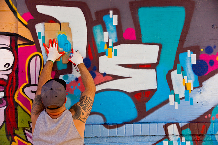An artist paints a graffiti mural on the wall of a derelict building in downtown Las Vegas.