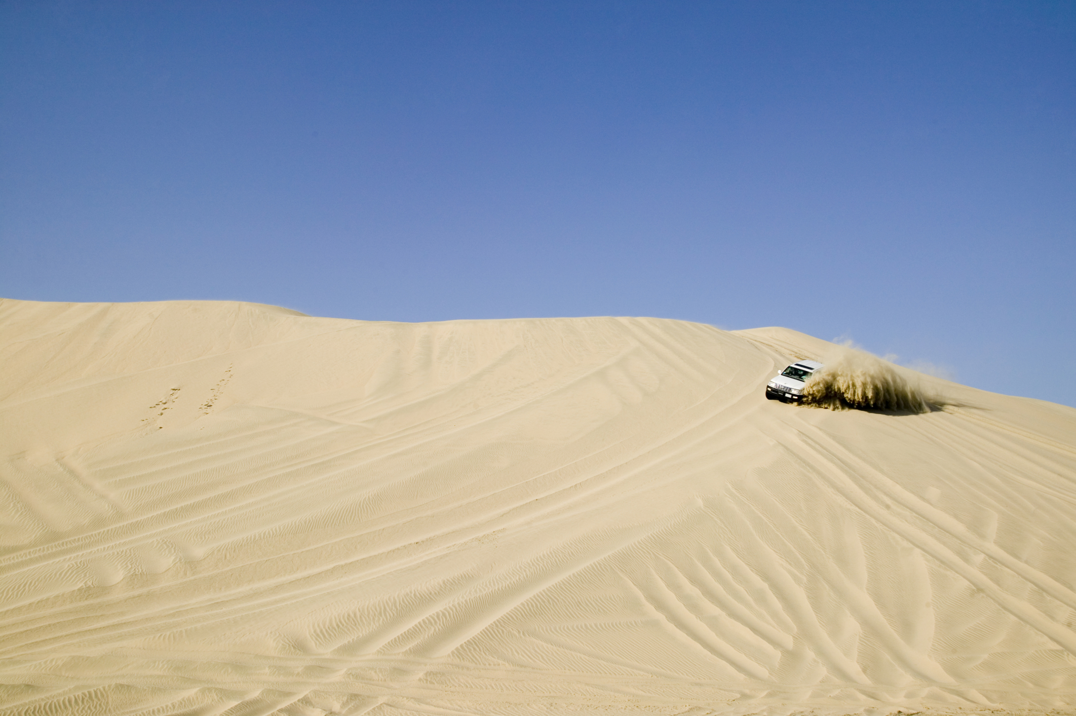 Driving the desert dunes. Image by Matilde Gattoni  / ArabianEye / Getty Images