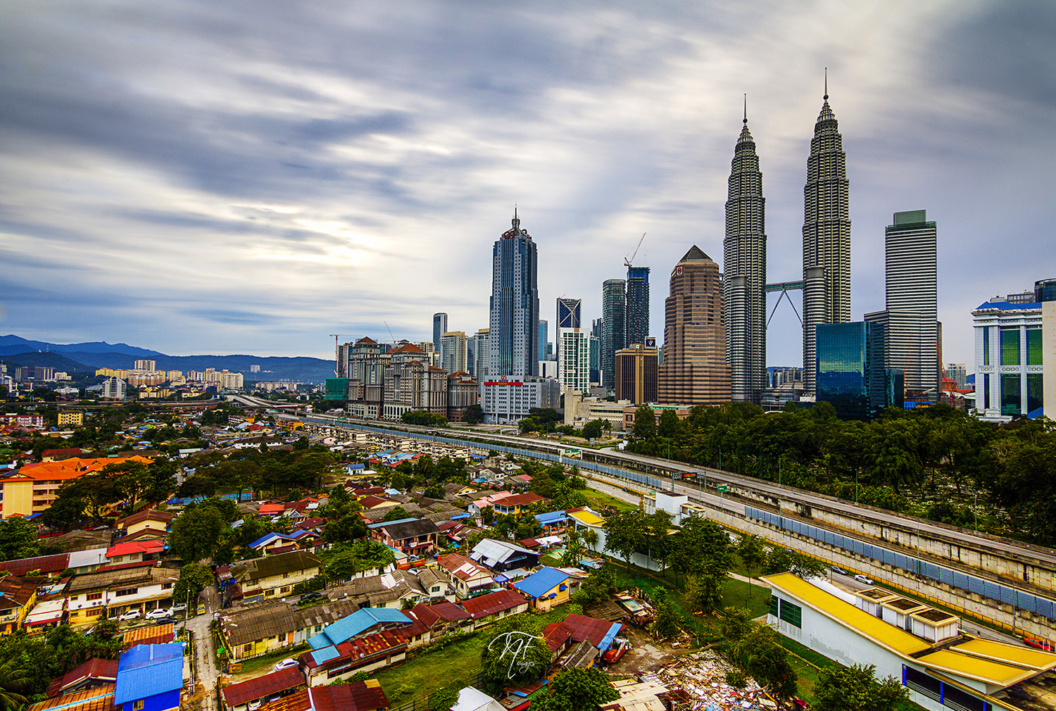 KL contrasts: traditional village Kampung Baru in the shadow of Kuala Lumpur's futuristic skyline. Image by Naim Fadil / CC BY-SA 2.0