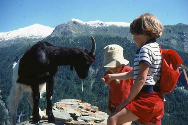 A young Clare Mercer (right) getting to know one of the locals in the Swiss Alps. Image by Clare Mercer / Lonely Planet.