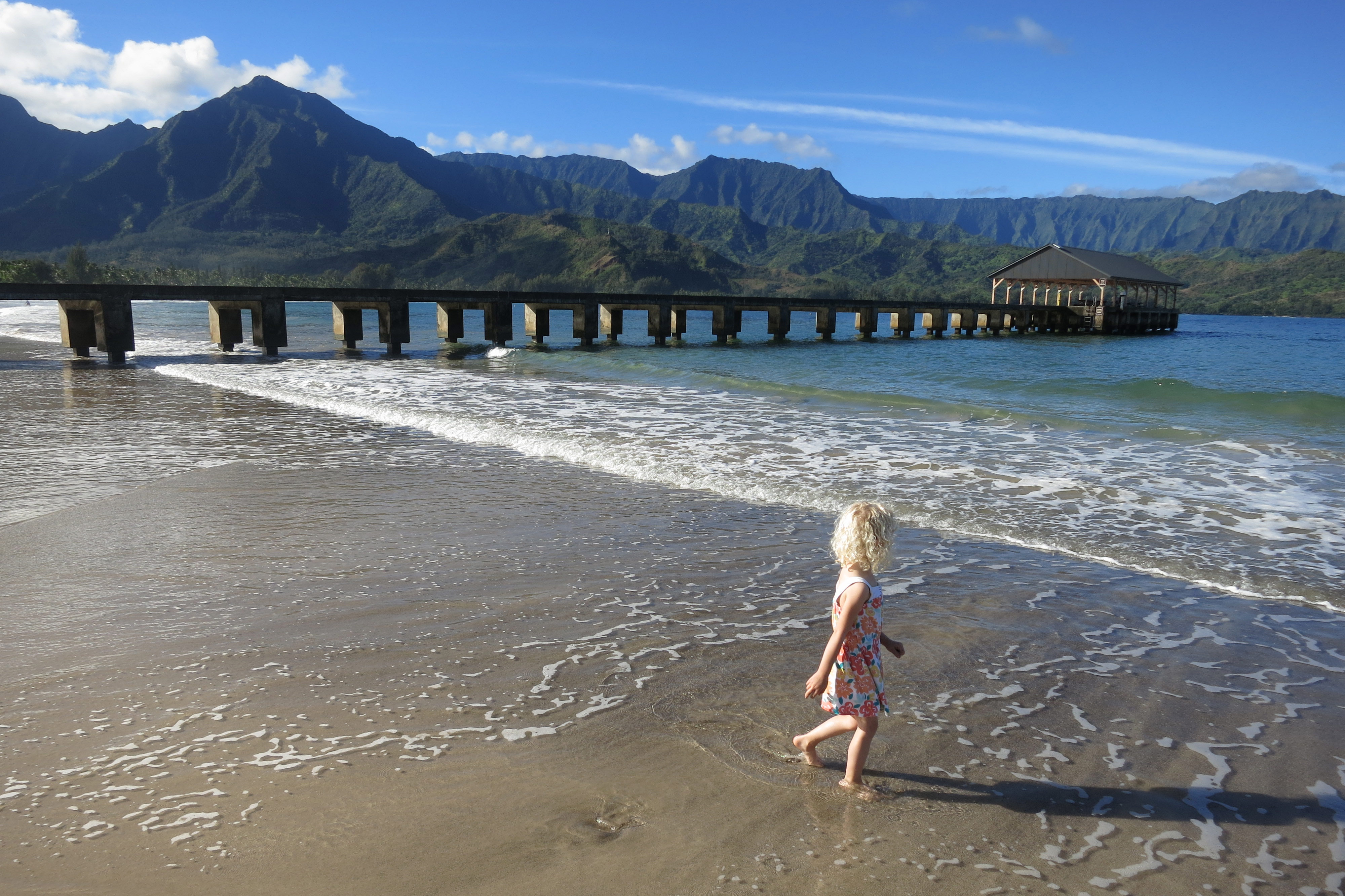 The waters near Hanalei Pier are perfect for young beachgoers. Image by Andy Murdock / Lonely Planet