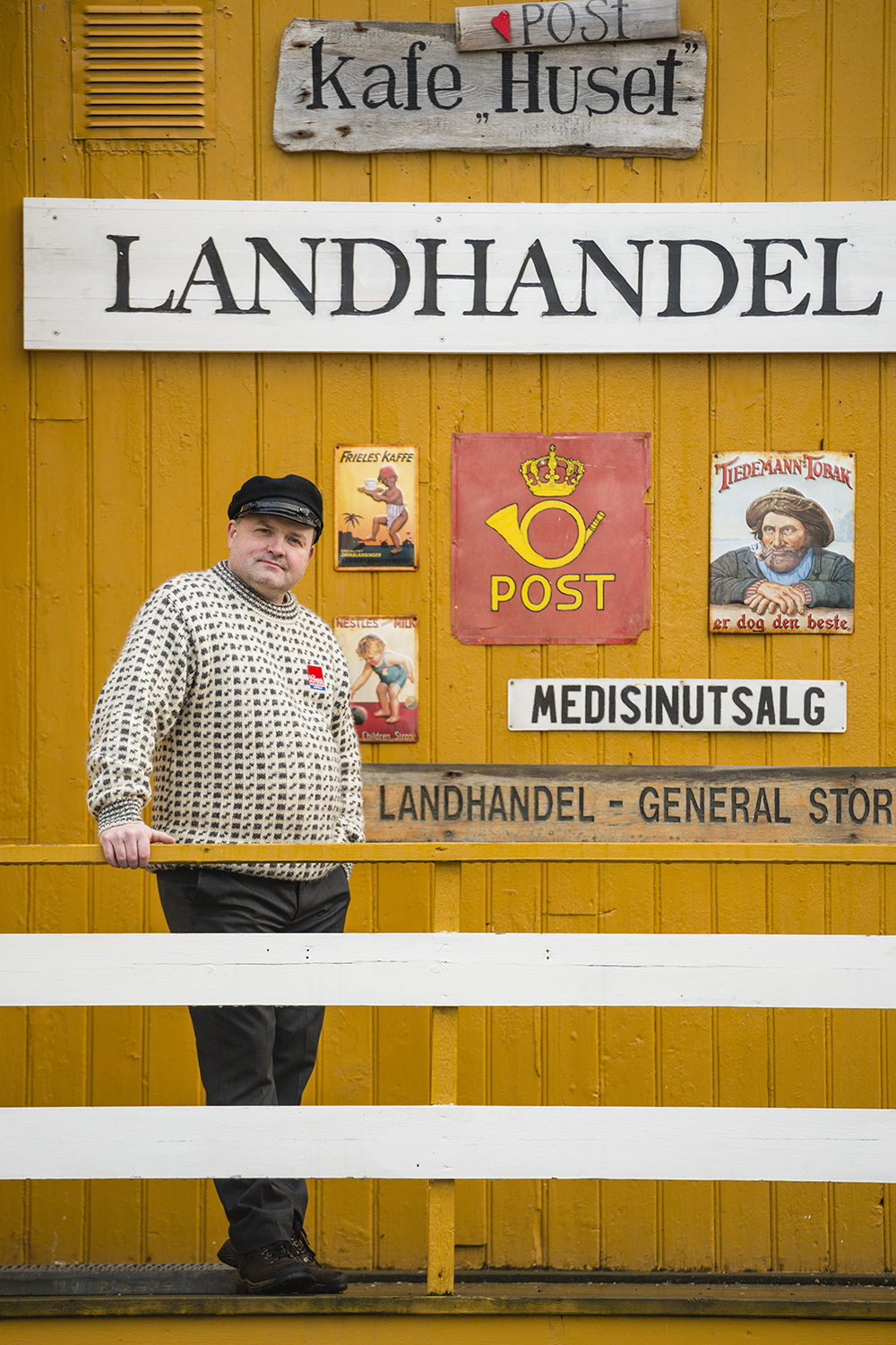 Ragnar Palsson leans out of a wooden house once used to store ice in Nusfjord, Lofoten, Norway