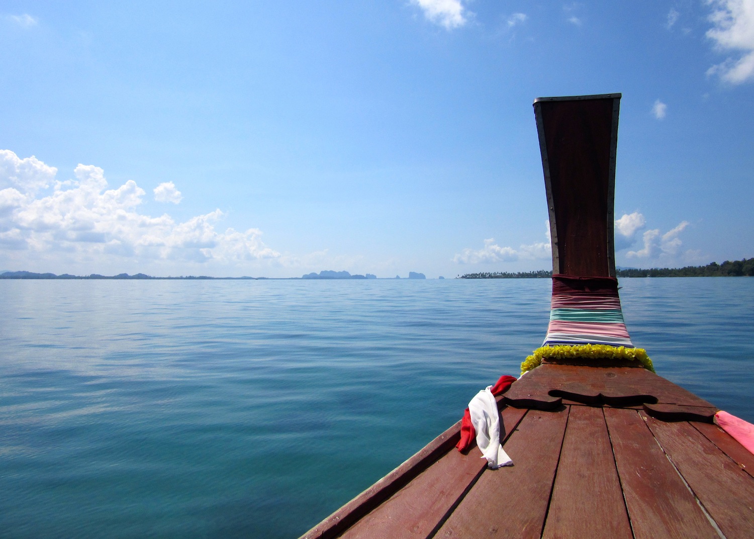 A long-tailed boat gliding between the Trang Islands © Isabella Noble / Lonely Planet
