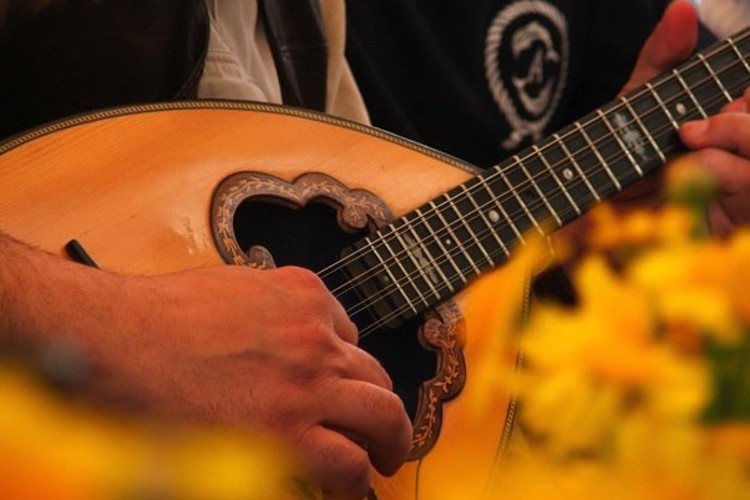 Playing the bouzouki at Easter lunch in Hydra. Image by Alexis Averbuck / Lonely Planet