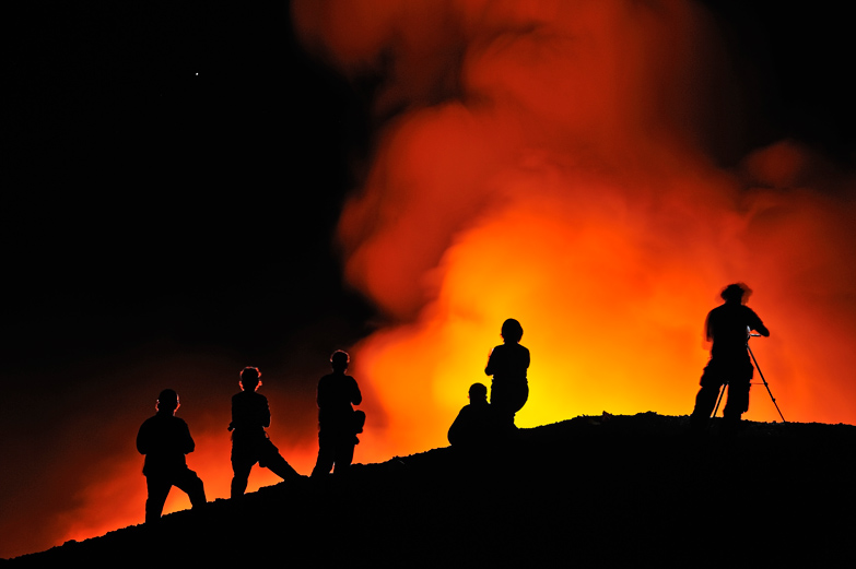 Watching lava flow at night on Kilauea volcano, Big Island. Image by Sami Sarkis / SuperStock / Getty Images.