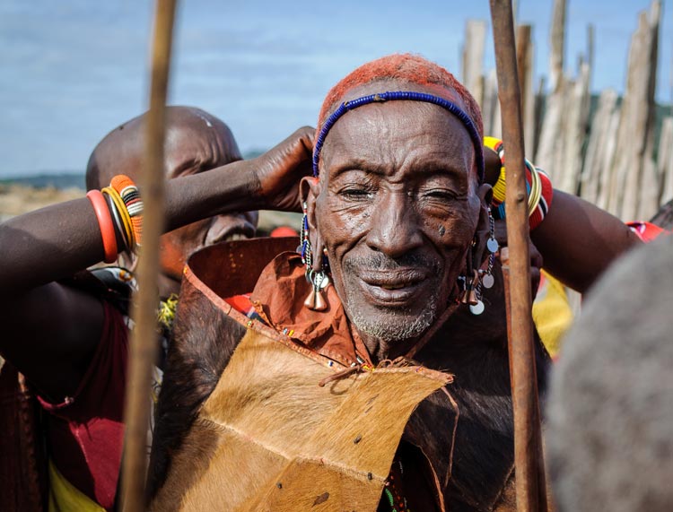 A goatskin cape and ceremonial headdress mark the auspicious occasion of this man's son being circumcised. Image by Michael Benanav / Lonely Planet.