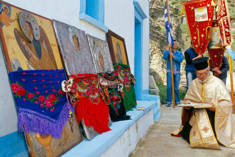 Priest praying during Lambri Triti festival, Olymbos, Karpathos. Image by Marco Simoni / Robert Harding / Getty Images