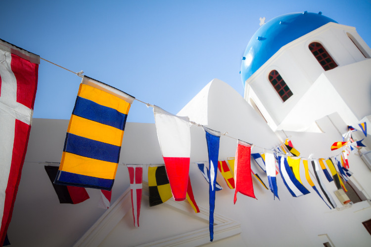 Festival flags above Oia church, Santorini. Image by Carl Stovell / Getty Images