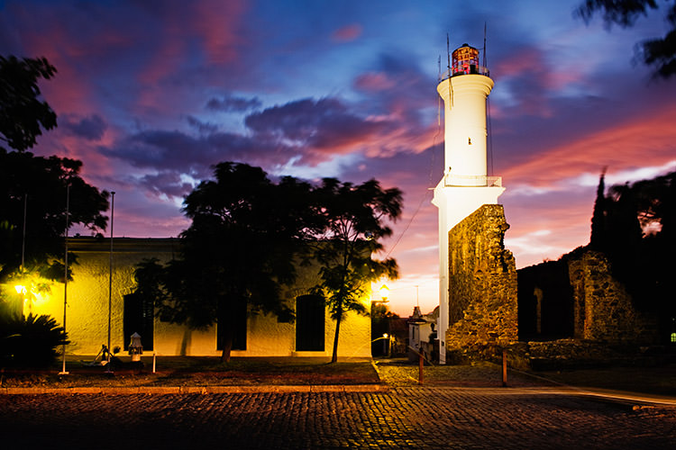 The sun sets on Colonia del Sacramento's historic lighthouse / Image by David Sanger / The Image Bank / Getty Images