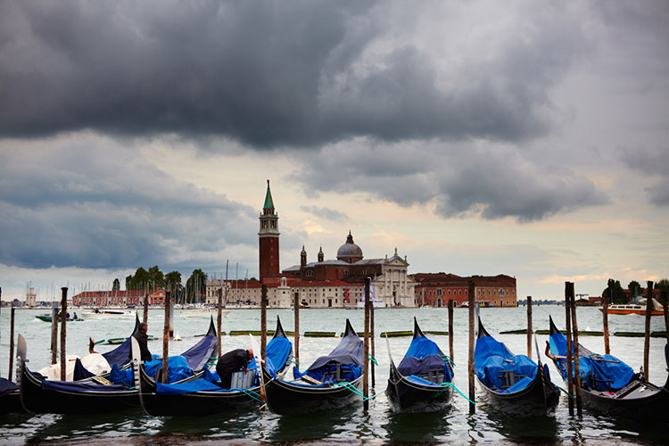 Gondolas in off-season Venice under suitably threatening skies. Image by Matt Munro / Lonely Planet