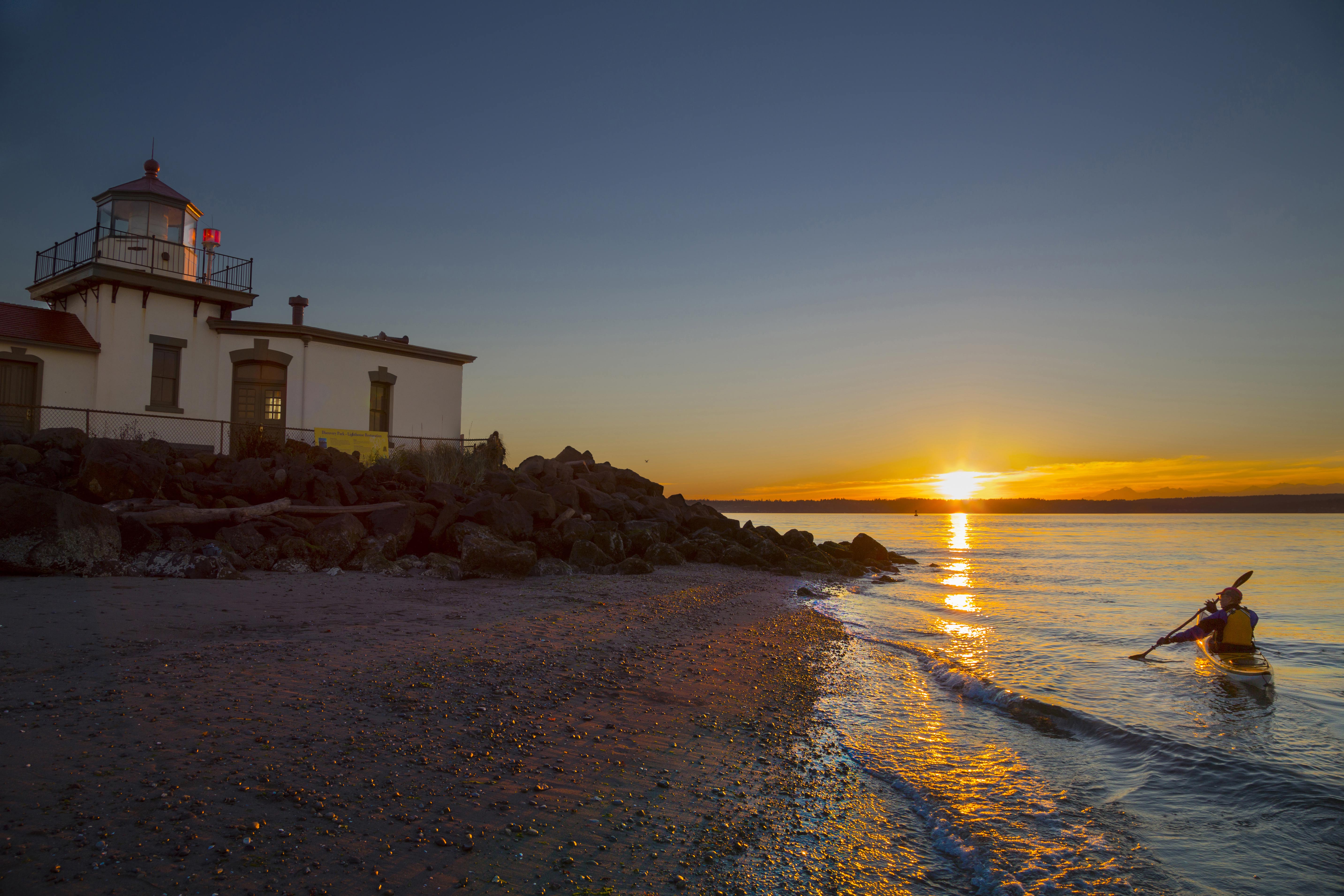 A kayaker takes a sunset trip near the West Point Lighthouse in Discovery Park. Image by Danita Delimont / Gallo Images / Getty