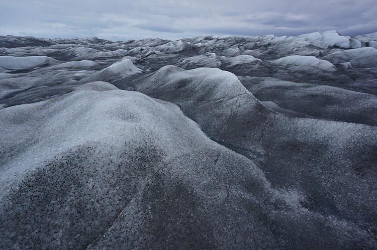 Wave-like formations of ice stretch out towards a cloudy horizon near Kangerlussuaq, Greenland