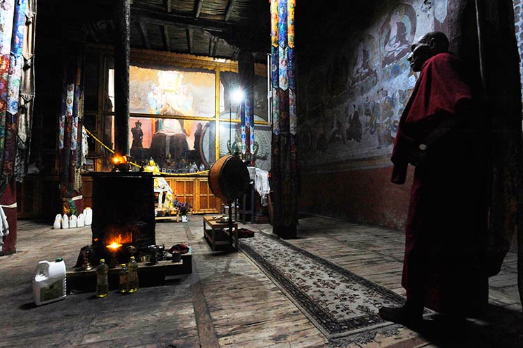 An elderly monk pauses in the modest prayer hall of Chamba Monastery in Hunder village in the Shyok River valley. Image by Amar Grover / Lonely Planet.
