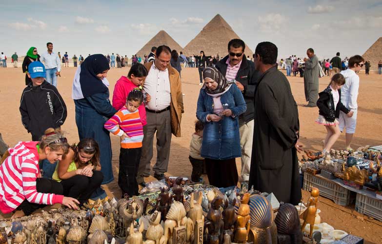 Tourists at souvenir stalls near the Pyramids of Giza, Egypt. Image by Richard I'Anson  / Lonely Planet Images / Getty Images .