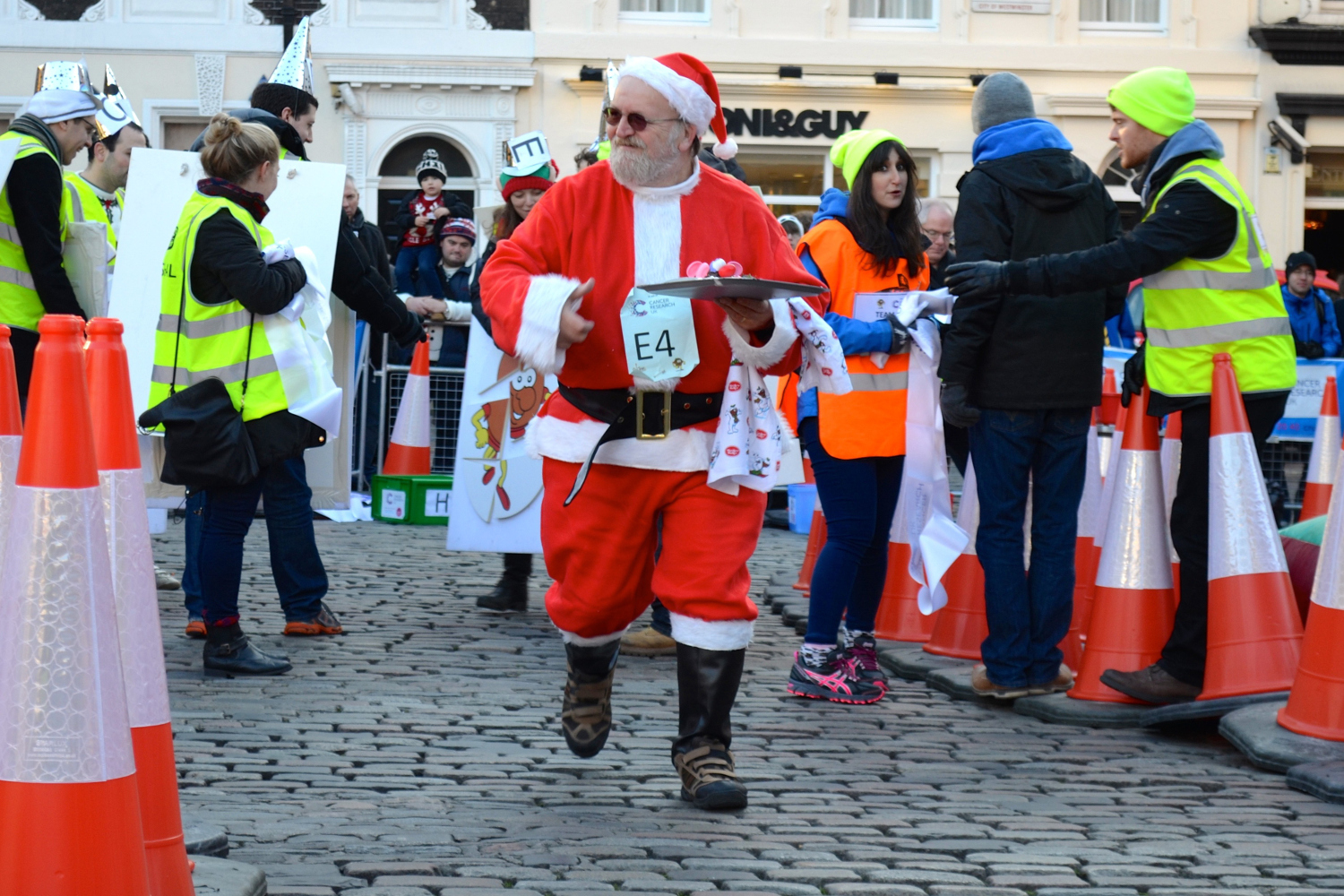 LONDON, UNITED KINGDOM -DECEMBER 6: People dressed as santa claus compete in the annual London Christmas pudding race at the Covent Garden on December 6, 2014, in a bid to raise money for Cancer Research UK and build up to the festive Christmas season. (Photo by Inci Gundag/Anadolu Agency/Getty Images)