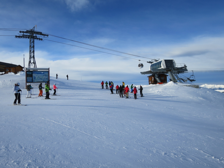Skiers pause at the top of a lift station, La Plagne, French Alps.