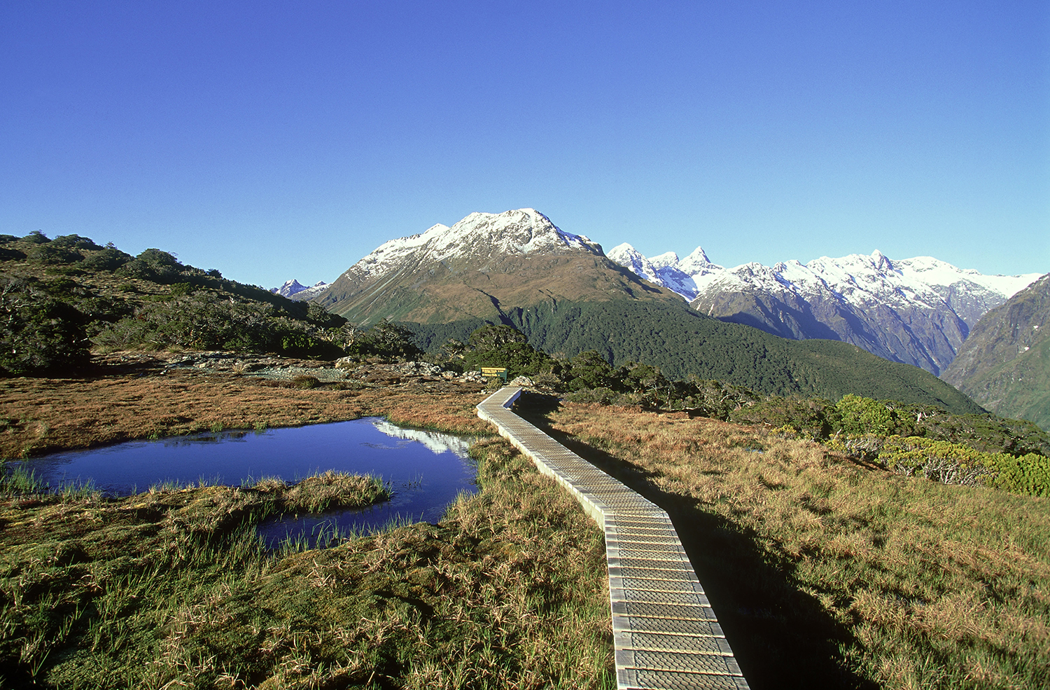 Blaze a trail past the snow-sprinkled mountains and yawning valleys of Fiordland National Park on New Zealand's Routeburn Track. Image by Grahame McConnell / Photolibrary / Getty Images