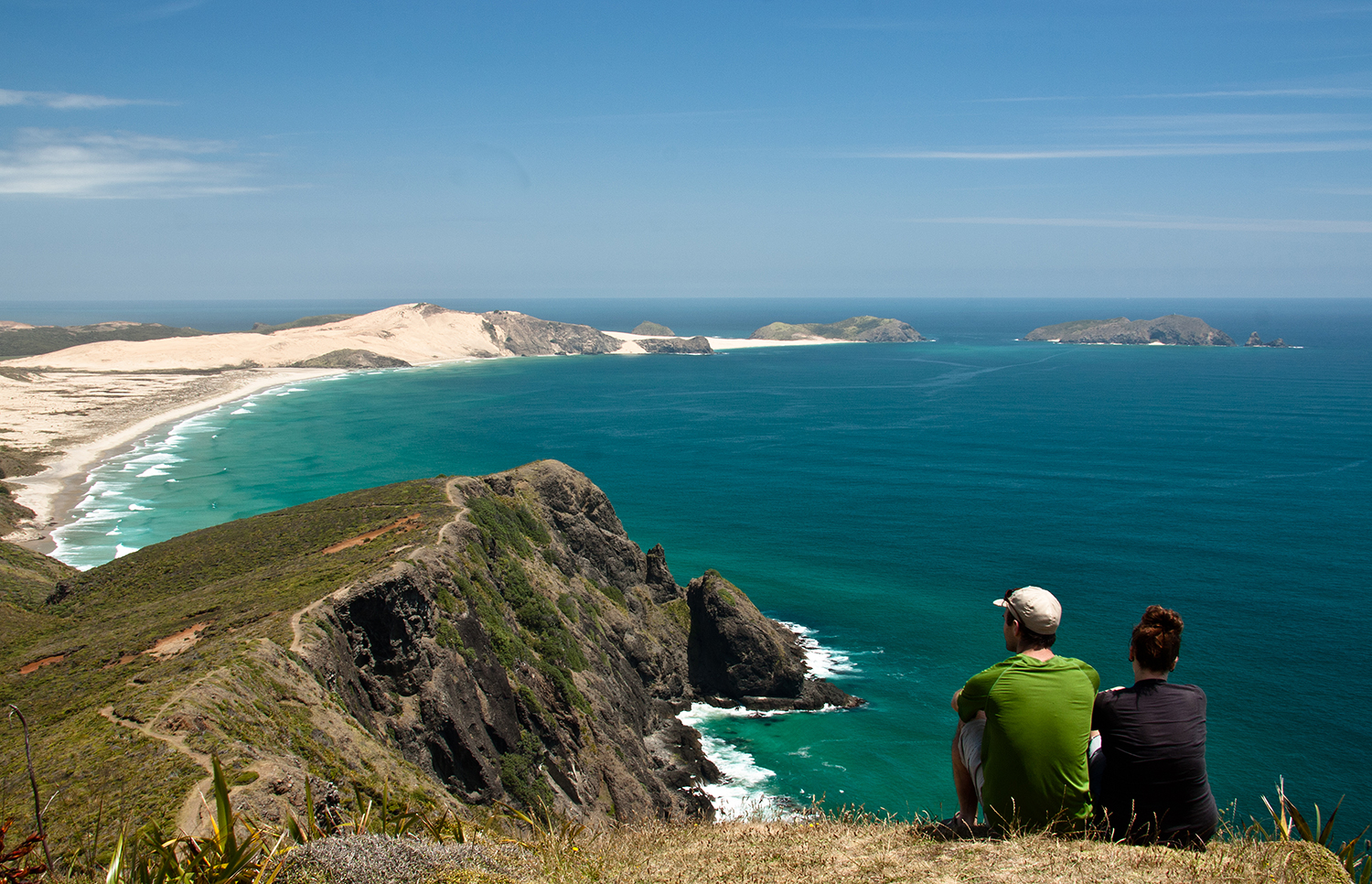 Want to picnic overlooking this view? Lace up your hiking boots for cliffside trails at Cape Reinga in New Zealand. Image by Dan / CC BY 2.0