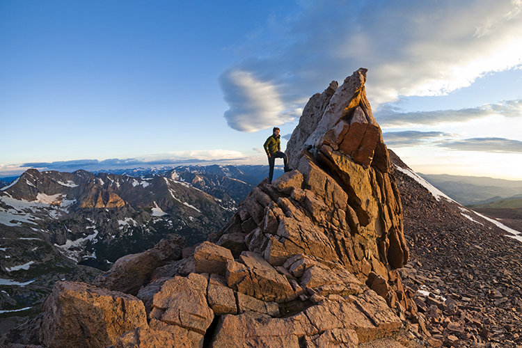 A hiker stands on Longs Peak. Image by Ethan Welty / Aurora / Getty