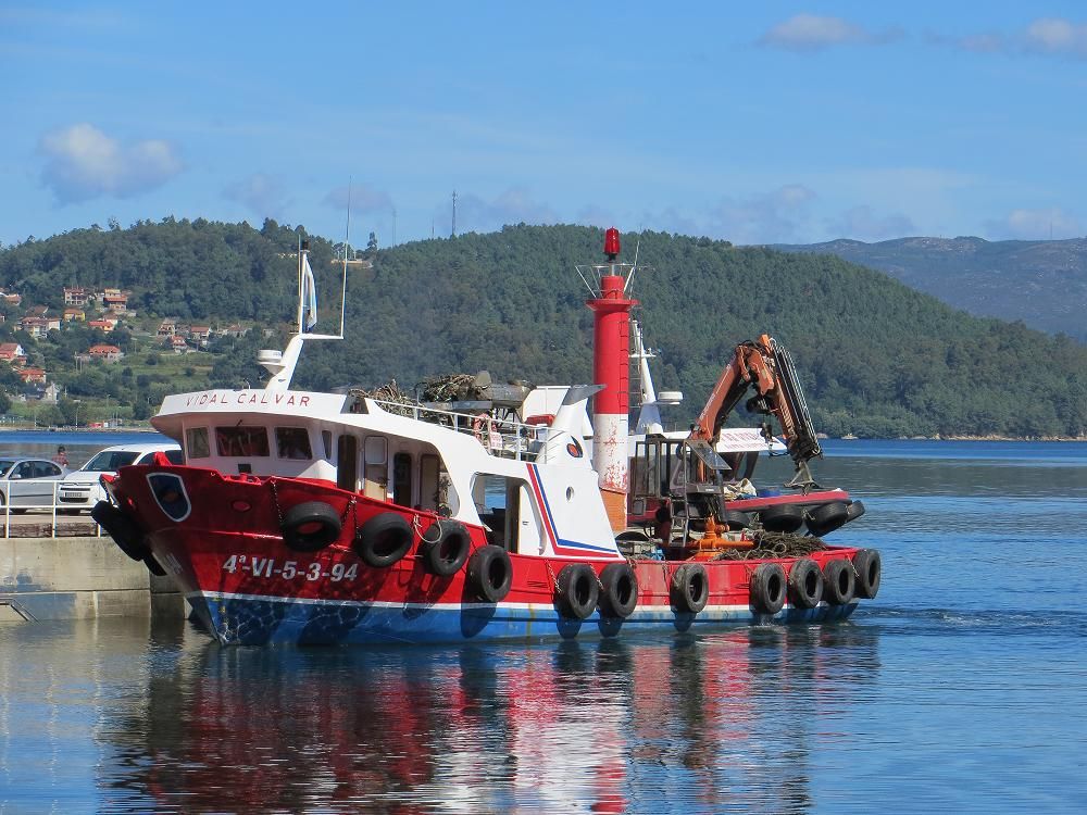 The unmistakable mussel ship awaits its crew docked at the port of San Adrián de Cobres, soon it will head to floating rafts where mussel are farmed. Try to taste boiled mussels with just a drop of lemon.