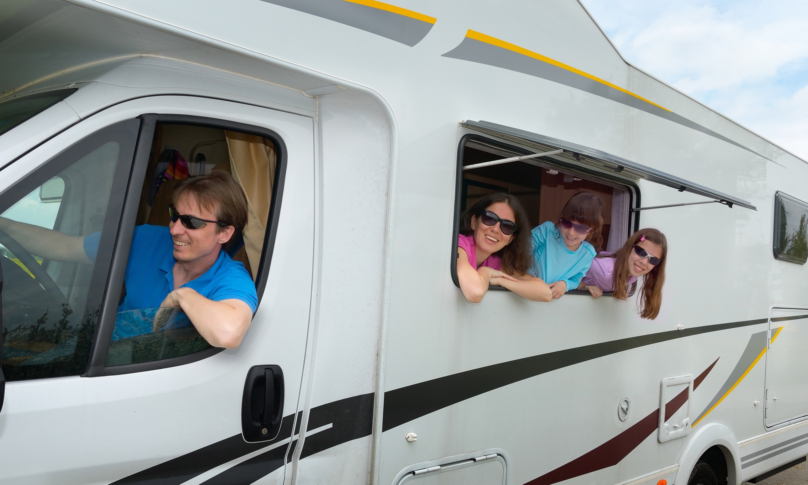 Kids hanging out of campervan (Shutterstock.com) 