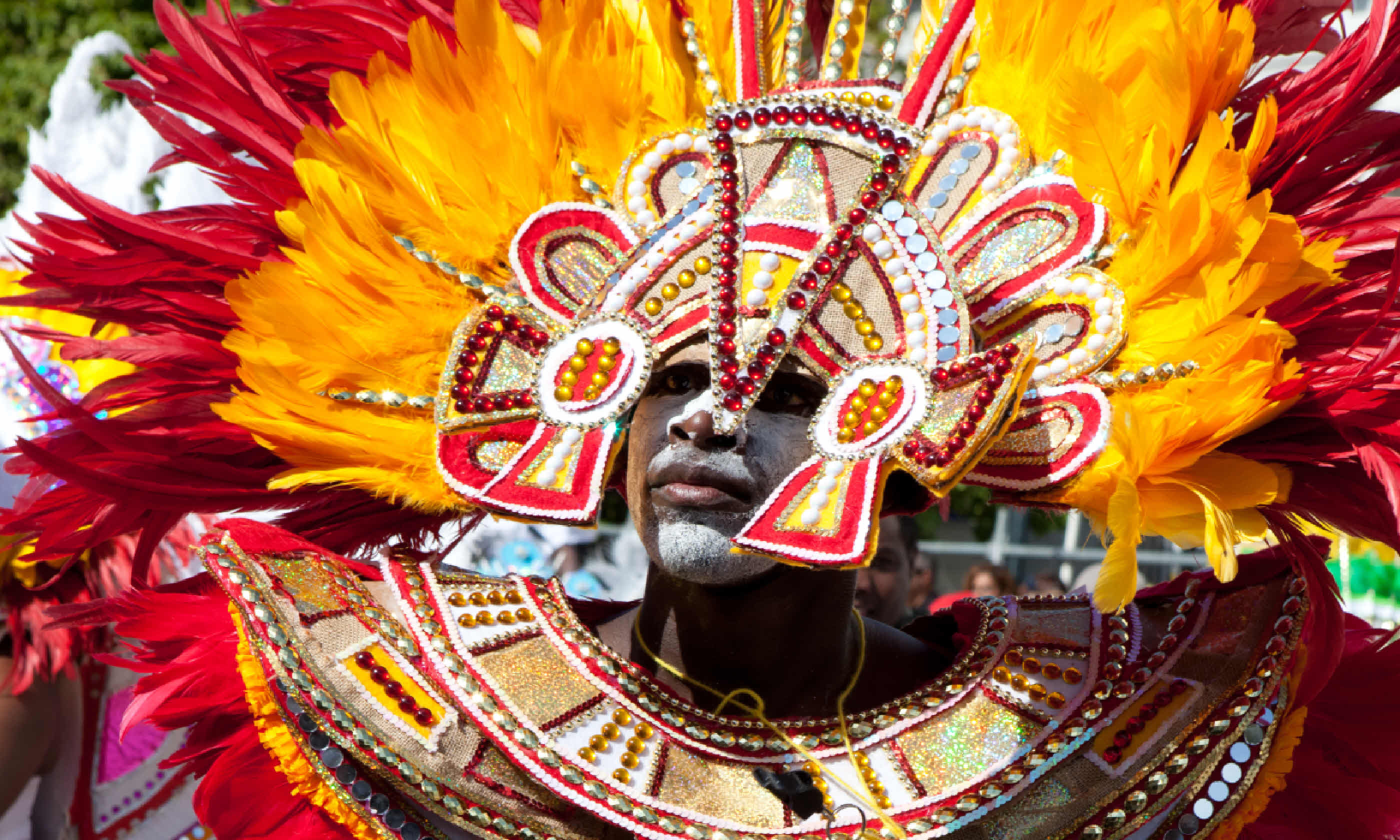 Male dancer dressed in orange and red feathers, Nassau (Shutterstock)