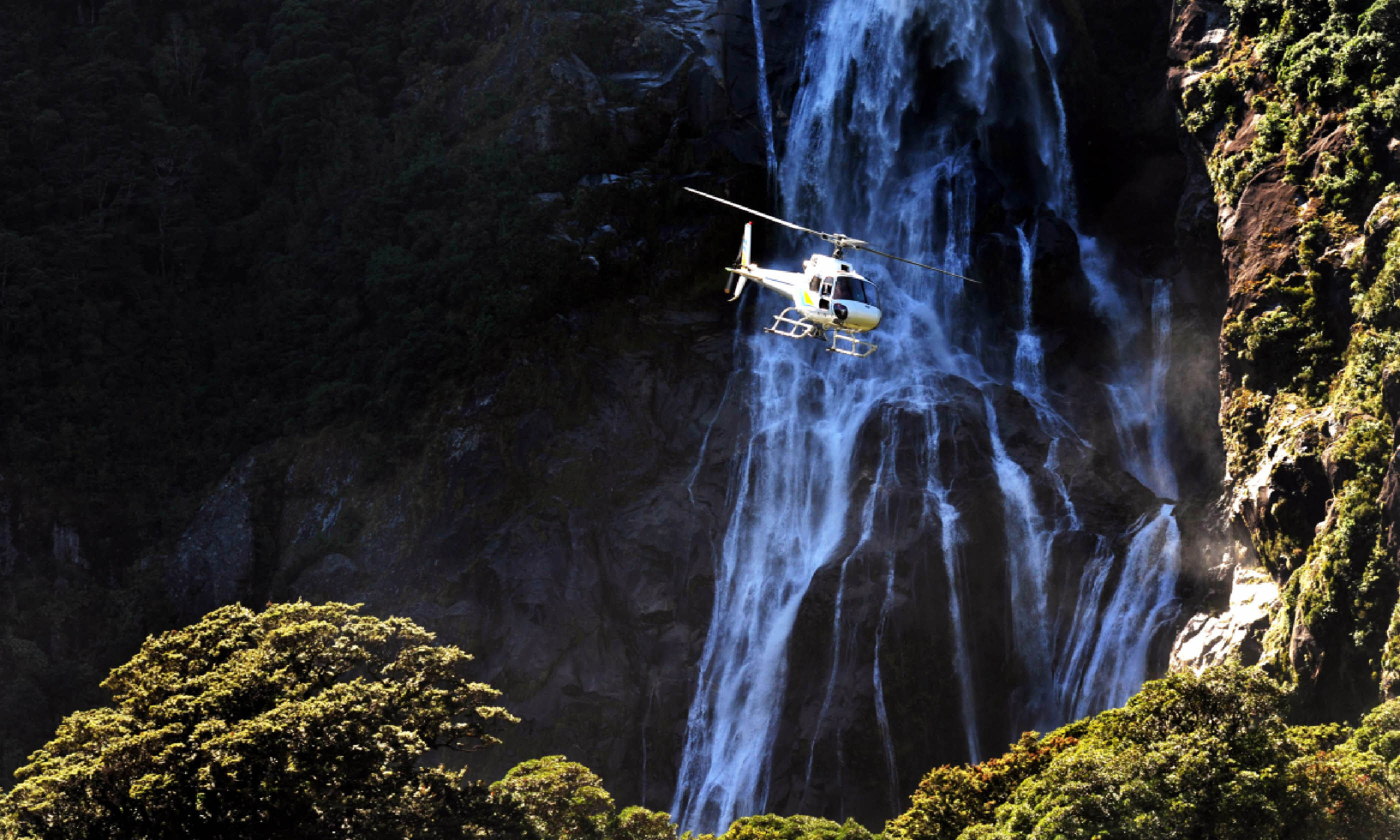A helicopter flies over Fiordland, southern New Zealand (Shutterstock)