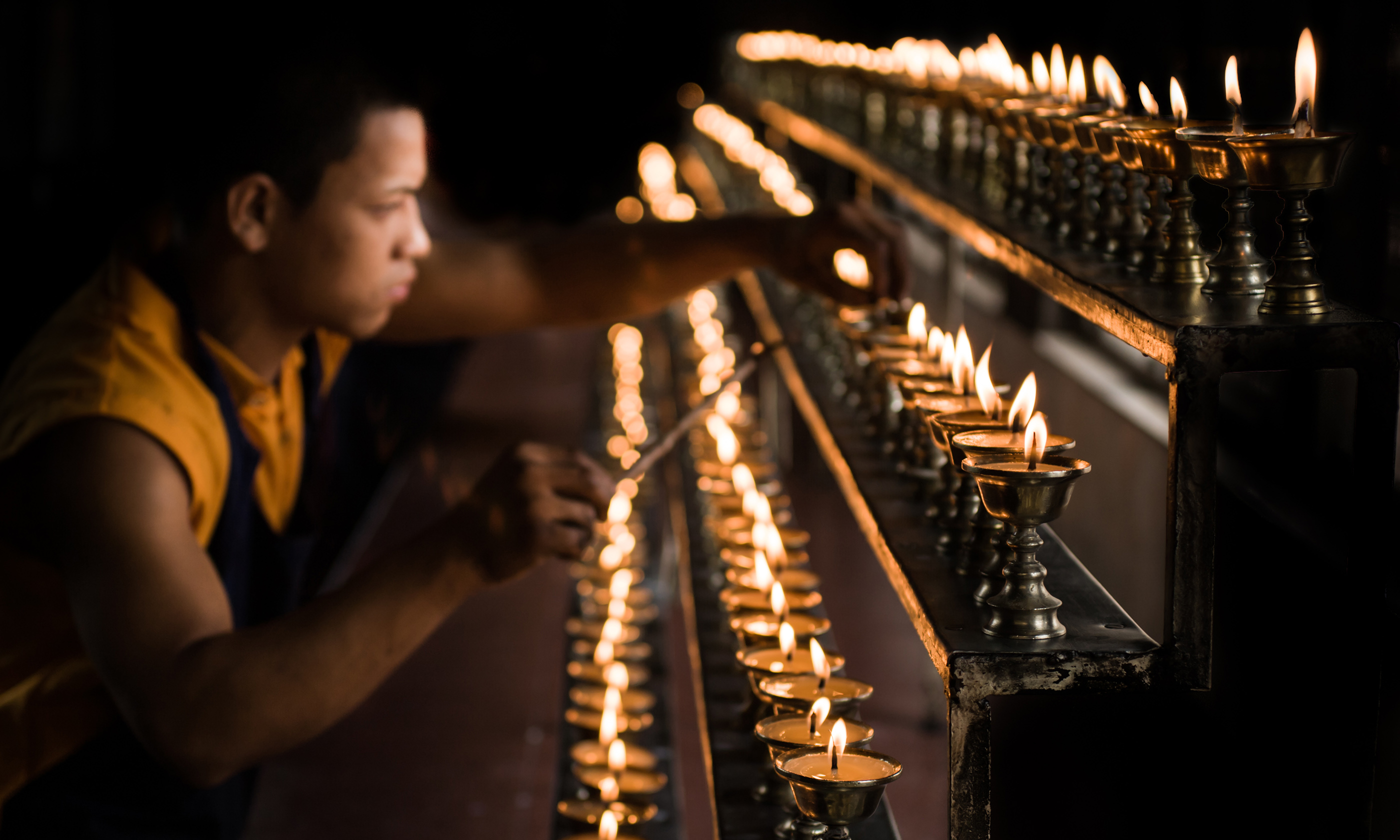 Monk with candles (Shutterstock.com)