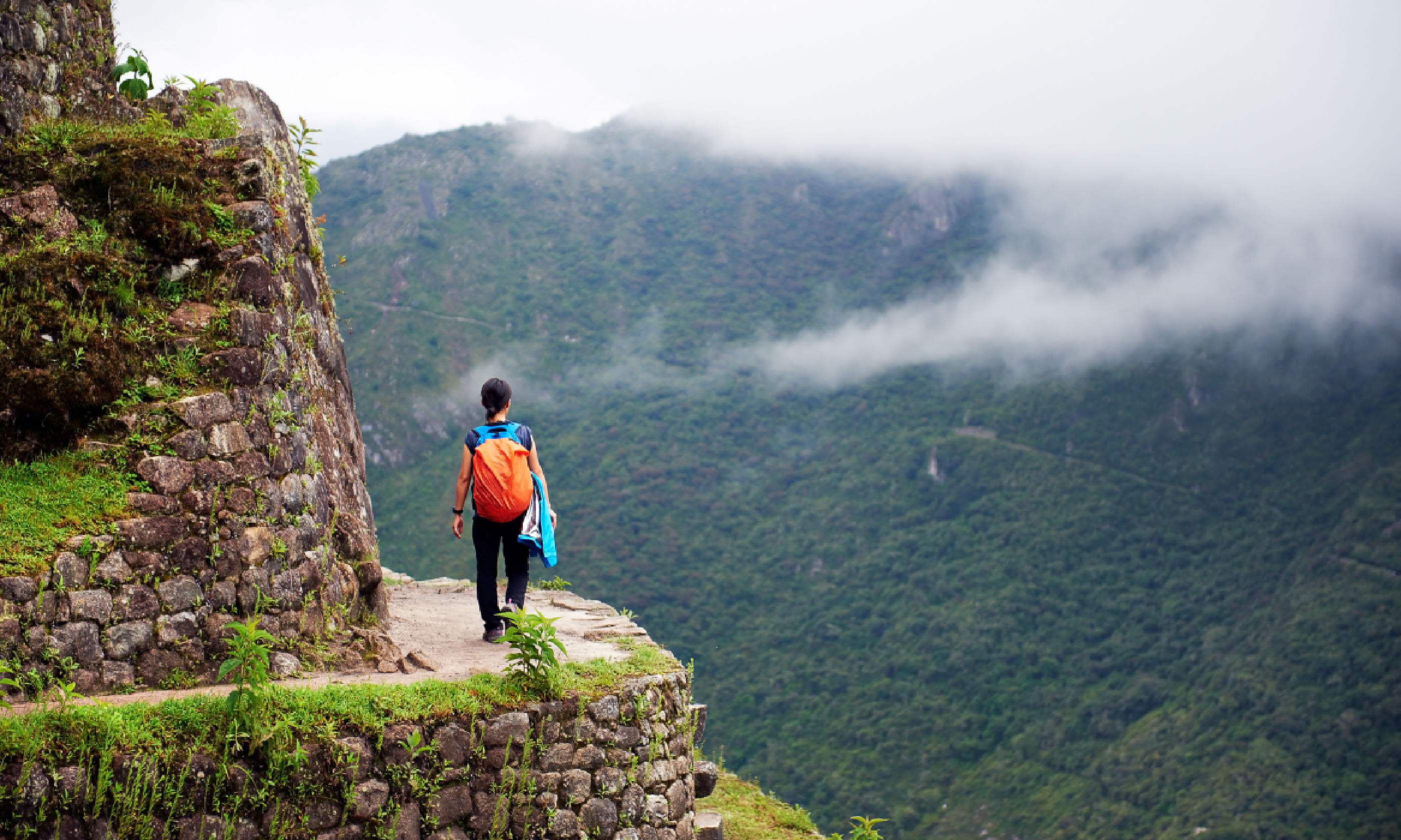 Women walking on the edge of a cliff, Machu Picchu, Peru (Shutterstock: see credit below)