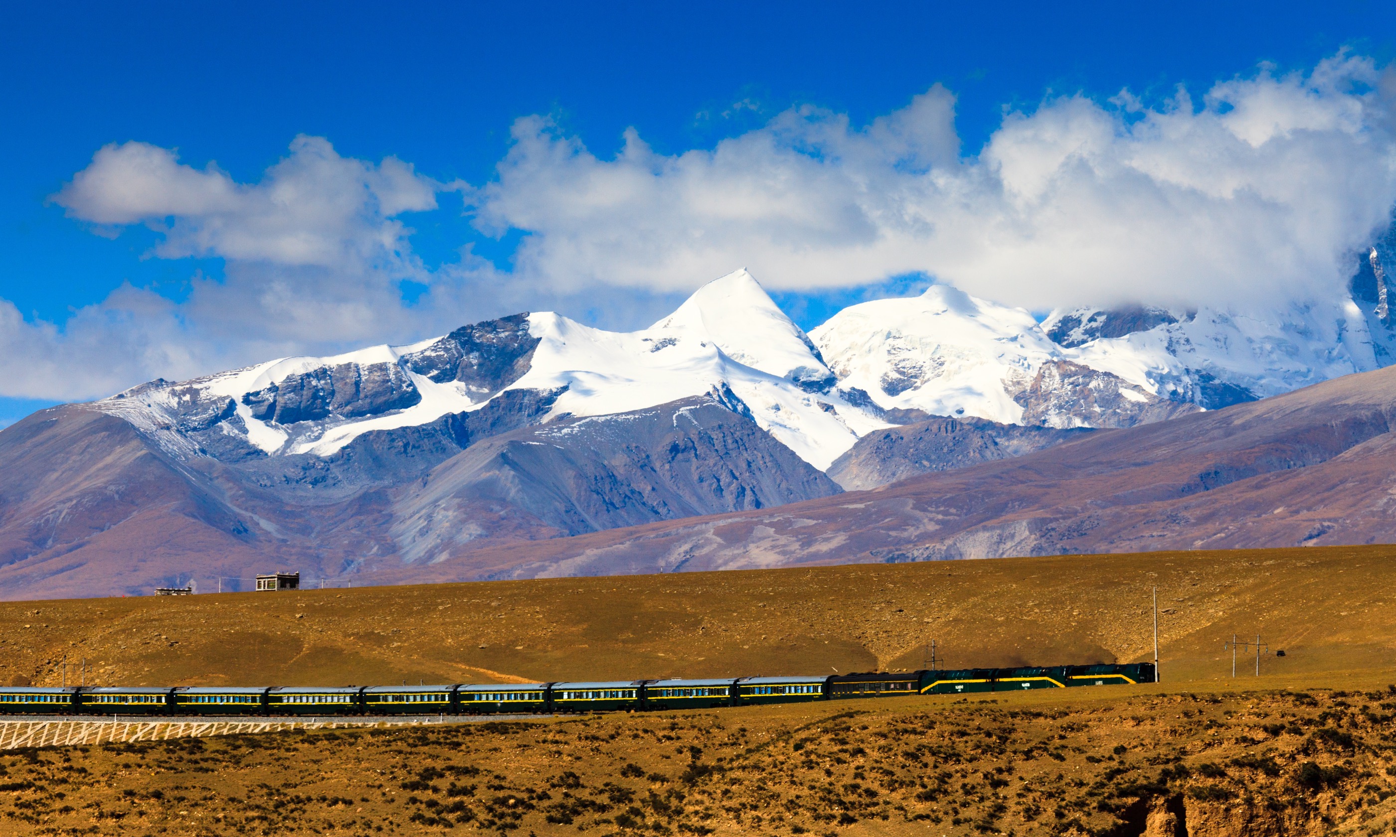 Train passing by Nyenchen Tanglha Mountains Tibet (Shutterstock.com. See main credit below)