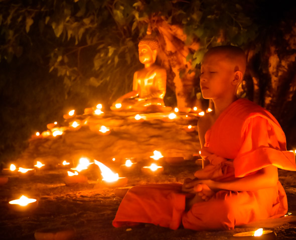 Novice Thai monk meditates at Wat Pan Tao, Chiang Mai