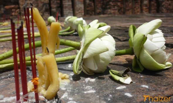 Buddhist offerings of incense sticks, candles and lotus flowers at a temple in Sukhothai