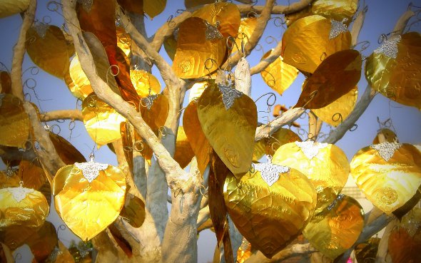 Gold leaves with inscriptions on an artificial tree in Chiang Mai