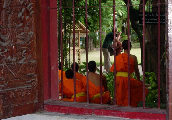 Novice monks watching tourists at Wat Phra Singh in Chiang Mai