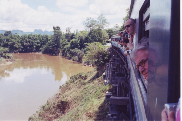 Tourists peering out of the train window on the Death Railway, Kanchanaburi