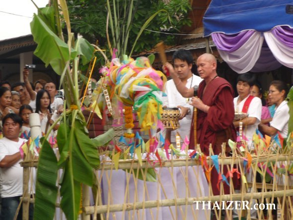 A Thai monk blesses the container of water used to anoint the main roof of the temple