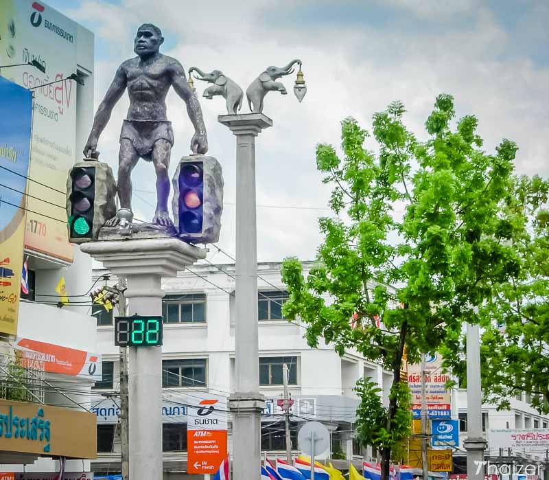 Caveman or Neanderthal man holding up traffic lights in Krabi Town