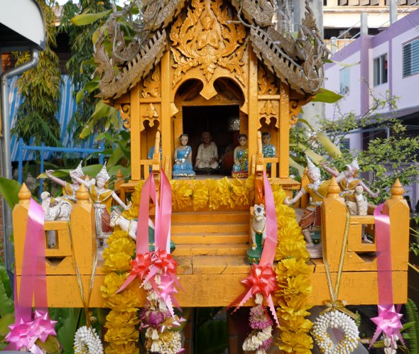miniature figures inside Thai spirit house