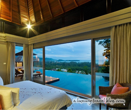 A bedroom with a view over an infinity pool and the sea beyond