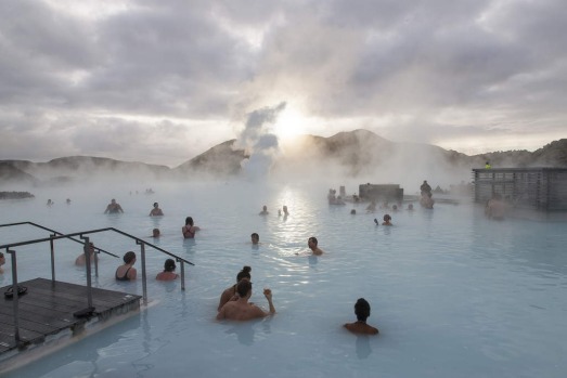 Tourists bathe in the Blue Lagoon geothermal spa as steam rises in Grindavik, Iceland.