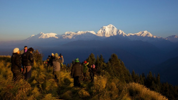 Tourists and trekkers enjoy view at dawn looking to Dhaulagiri from Poon Hill, Annapurna Region, Himalayas, Nepal, Asia.