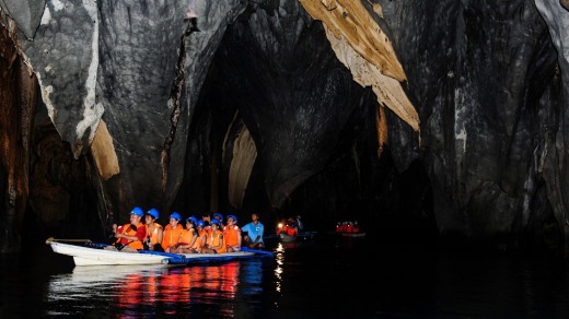 Tourists in a rowing boat enter the underground river in Puerto Princesa River National Park.