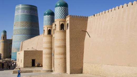 The Kukhana Ark fortress in front of the turquoise-tiled Kalta Minor Minaret in Ichon-Qala in Uzbekistan, Central Asia.